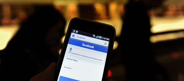 A man checks facebook on his smartphone while waiting for a train in a metro station in Washington, DC, on May 9, 2012.  - Sputnik Afrique