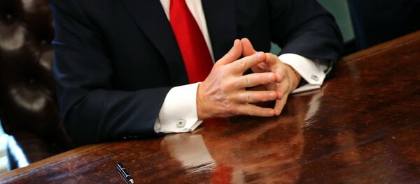 U.S. President Donald Trump sits at the Oval Office of the White House after signing an executive order cutting regulations in Washington U.S., January 30, 2017. - Sputnik Afrique