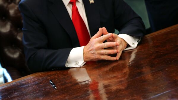 U.S. President Donald Trump sits at the Oval Office of the White House after signing an executive order cutting regulations in Washington U.S., January 30, 2017. - Sputnik Afrique