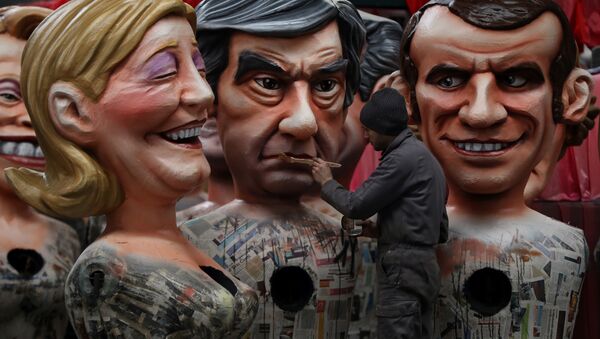 A man puts the final touche on a giant figure depicting right-wing presidential candidates Francois Fillon (C) next to others depicting far right presidential candidate Marine Le Pen (L) and centrist independent presidential candidate Emmanuel Macron, on January 27, 2017 in Nice, southeastern France, during the preparation of the 133rd Nice Carnival. - Sputnik Afrique