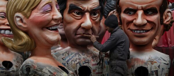 A man puts the final touche on a giant figure depicting right-wing presidential candidates Francois Fillon (C) next to others depicting far right presidential candidate Marine Le Pen (L) and centrist independent presidential candidate Emmanuel Macron, on January 27, 2017 in Nice, southeastern France, during the preparation of the 133rd Nice Carnival. - Sputnik Afrique