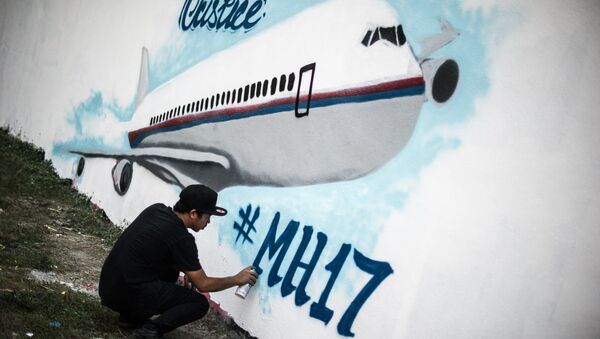 Der Künstler Wan Ahmad Farid Ramli arbeitet an einer Wandmalerei über den Absturz von Flug MH17, den 26. Juli 2014 in Kuala Lumpur. - Sputnik Afrique