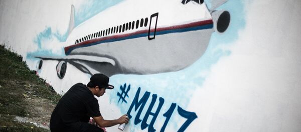 Der Künstler Wan Ahmad Farid Ramli arbeitet an einer Wandmalerei über den Absturz von Flug MH17, den 26. Juli 2014 in Kuala Lumpur. - Sputnik Afrique