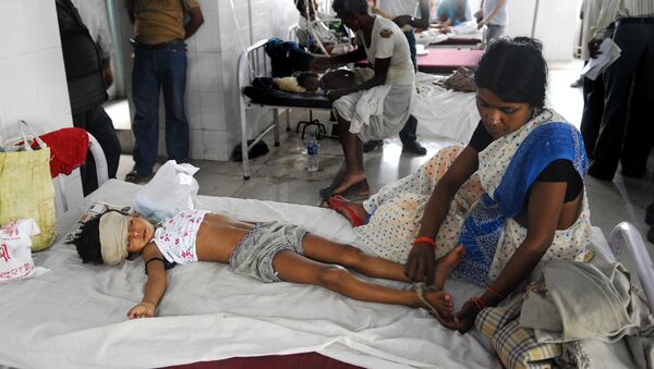 An Indian woman attends to a child lying in a bed of a hospital in Muzzafarapur, some 100kms north of Patna on June 23, 2011. - Sputnik Afrique