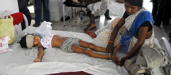 An Indian woman attends to a child lying in a bed of a hospital in Muzzafarapur, some 100kms north of Patna on June 23, 2011. - Sputnik Afrique