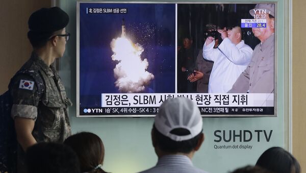 South Korean army soldier watches a TV news program showing images published in North Korea's Rodong Sinmun newspaper of North Korea's ballistic missile believed to have been launched from underwater and North Korean leader Kim Jong-un, at Seoul Railway station in Seoul, South Korea (File) - Sputnik Afrique