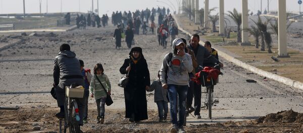 Civilians move away as Iraqi security forces fight against Islamic State militants on the eastern side of Mosul, Iraq, Wednesday, Jan. 18, 2017 - Sputnik Afrique