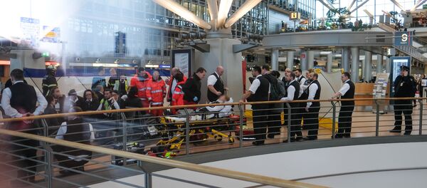 Firefighters take care of a person on a stretcher inside Hamburg airport on February 12, 2017 in Hamburg, northern Germany, as German emergency services evacuated the airport after people reported an unusual smell as well as respiratory ailments and watering eyes - Sputnik Afrique