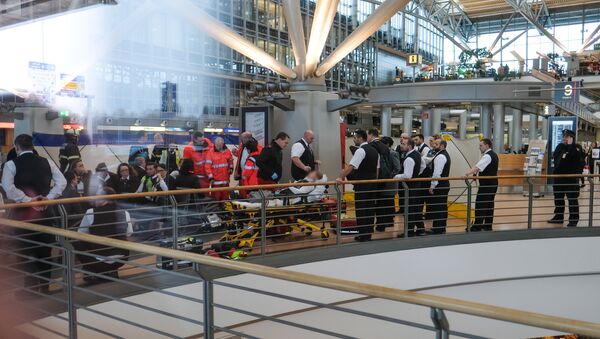 Firefighters take care of a person on a stretcher inside Hamburg airport on February 12, 2017 in Hamburg, northern Germany, as German emergency services evacuated the airport after people reported an unusual smell as well as respiratory ailments and watering eyes - Sputnik Afrique