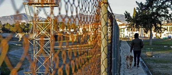 A woman walks her dog on the Turkish side of the green line, a UN controlled buffer zone separating the divided Cypriot capital Nicosia, on January 13, 2017. - Sputnik Afrique