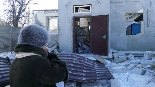 A woman by a house damaged by the shelling of the Ukrainian army in Makeevka, Donetsk Region - Sputnik Afrique
