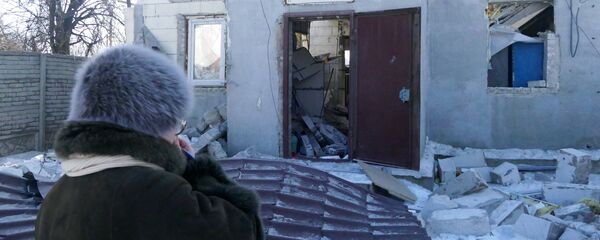 A woman by a house damaged by the shelling of the Ukrainian army in Makeevka, Donetsk Region - Sputnik Afrique