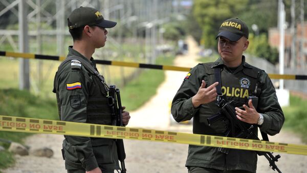 Policemen stand guard at a cordoned-off police station and a power substation where a police officer was killed and his body booby-trapped, in northern Bogota, on December 29, 2016. Colombia accused the ELN rebels Thursday of killing a Bogota policeman, then hiding explosives by his body and detonating them when colleagues rushed to his side, wounding five. - Sputnik Afrique