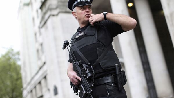An armed police officer speaks on his radio as he patrols near the Ministry of Defence in London, Britain May 11, 2016 - Sputnik Afrique