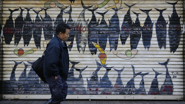 A worker walks past a shutter featuring the illustration of the famous tuna auction outside Tsukiji fish market in Tokyo, Monday, Nov. 28, 2016. - Sputnik Afrique
