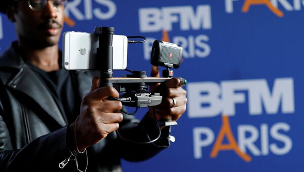 A video journalist uses an Apple iPhone 7 Plus smart phone to film during a press conference for the launching of the news channel, BFM Paris, in Paris, France, October 13, 2016 - Sputnik Afrique
