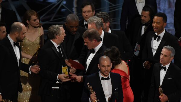An Oscar show producer (3L) shows the winners card to the cast of La La Land after it mistakenly won the best picture instead of Moonlight at the 89th Oscars on February 26, 2017 in Hollywood, California. - Sputnik Afrique