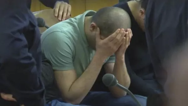 A defendant covers his face at the beginning of his trial on gang-raping a German tourist in Vienna, Austria, Thursday, March 2, 2017. - Sputnik Afrique