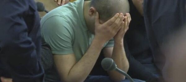 A defendant covers his face at the beginning of his trial on gang-raping a German tourist in Vienna, Austria, Thursday, March 2, 2017. - Sputnik Afrique