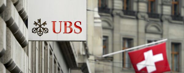 A Swiss flag is seen behind a sign of Swiss bank giant UBS on June 11, 2013 in Basel. - Sputnik Afrique