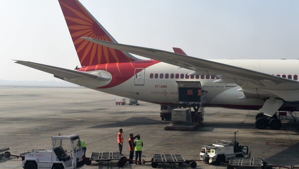 Airport workers load an Air India jet at the main terminal of the Indira Gandhi International airport in New Delhi on November 25, 2014 - Sputnik Afrique