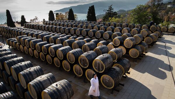 In this photo taken on Tuesday, Oct. 28, 2014, Rameta Kushkhova walks by barrels of wine in the state-owned Massandra winery in Yalta, Crimea - Sputnik Afrique