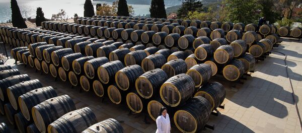 In this photo taken on Tuesday, Oct. 28, 2014, Rameta Kushkhova walks by barrels of wine in the state-owned Massandra winery in Yalta, Crimea - Sputnik Afrique