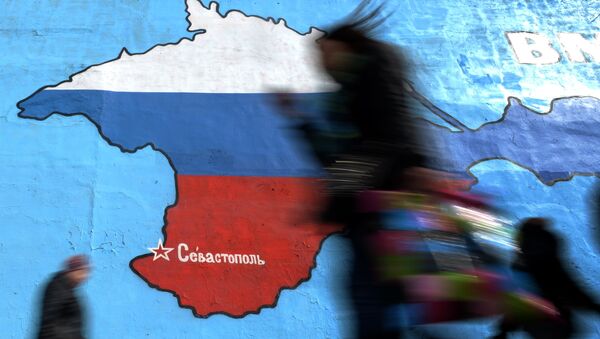 Pedestrians walk past an wall painting depicting a map of Crimean peninsula bearing the colours of Russia's national flag in Moscow, on March 31, 2014. - Sputnik Afrique