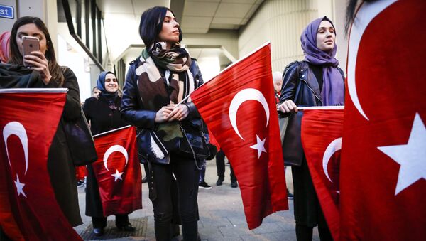 Dutch Turkish demonstrators hold Turkish flags as they gather outside the Turkish consulate in Rotterdam, on March 11, 2017 after Netherlands refused Turkish Foreign Minister Mevlut Cavusoglu permission to land for a rally to gather support for a referendum on boosting Turkish president Erdogan's powers. - Sputnik Afrique