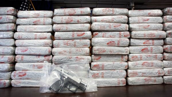 A firearm and 154 pounds of heroin worth at least $50 million are displayed at a Drug Enforcement Administration news conference. - Sputnik Afrique