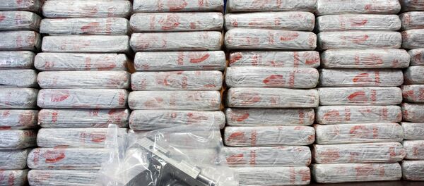 A firearm and 154 pounds of heroin worth at least $50 million are displayed at a Drug Enforcement Administration news conference. - Sputnik Afrique
