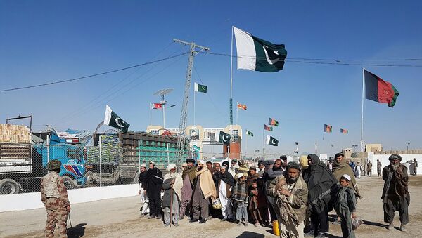 In this photograph taken on January 7, 2017, travellers are watched by Pakistan security personnel as they wait to cross the border between Pakistan and Afghanistan at Chaman. - Sputnik Afrique
