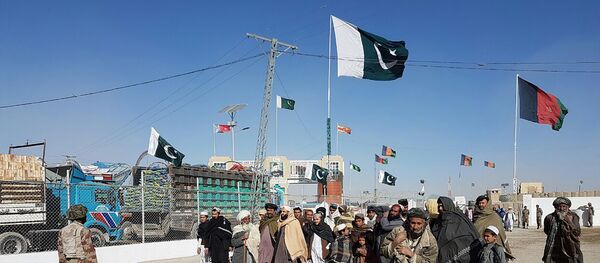 In this photograph taken on January 7, 2017, travellers are watched by Pakistan security personnel as they wait to cross the border between Pakistan and Afghanistan at Chaman. - Sputnik Afrique