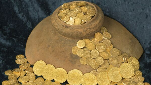 Over 350 gold coins from a sunken Spanish Treasure are seen in an undated handout picture courtesy of 1715 Fleet - Queens Jewels. Florida treasure hunters found the trove of $4.5 million worth of Spanish gold coins 300 years to the day after a fleet of ships sunk in a hurricane while en route from Havana to Spain, the salvage owner said August 19, 2015 - Sputnik Afrique