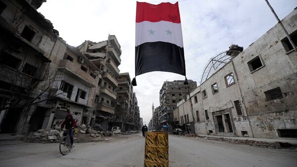 A Syrian national flag hangs in a damaged neighbourhood in Aleppo, Syria - Sputnik Afrique