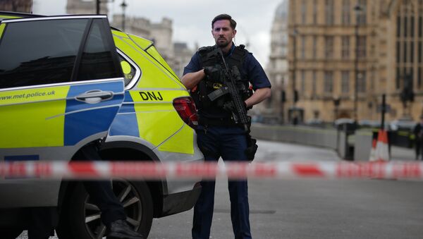 An armed police officer guards inside a police cordon outside the Houses of Parliament in central London on March 22, 2017 during an emergency incident. - Sputnik Afrique