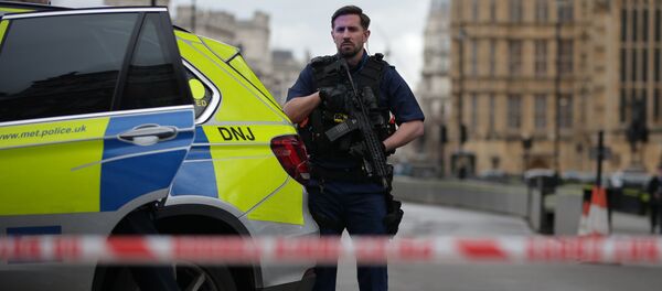 An armed police officer guards inside a police cordon outside the Houses of Parliament in central London on March 22, 2017 during an emergency incident. - Sputnik Afrique