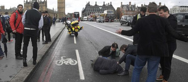 An injured person is assisted after an incident on Westminster Bridge in London - Sputnik Afrique