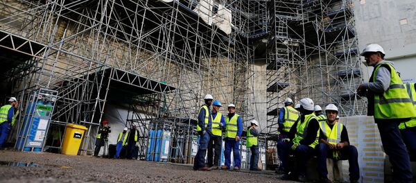 Workers stand at the construction site of the European Pressurised Reactor project (EPR) in Flamanville, northwestern France, on November 16, 2016. - Sputnik Afrique