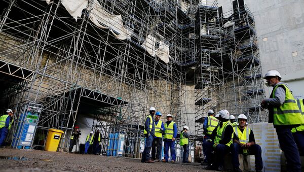 Workers stand at the construction site of the European Pressurised Reactor project (EPR) in Flamanville, northwestern France, on November 16, 2016. - Sputnik Afrique