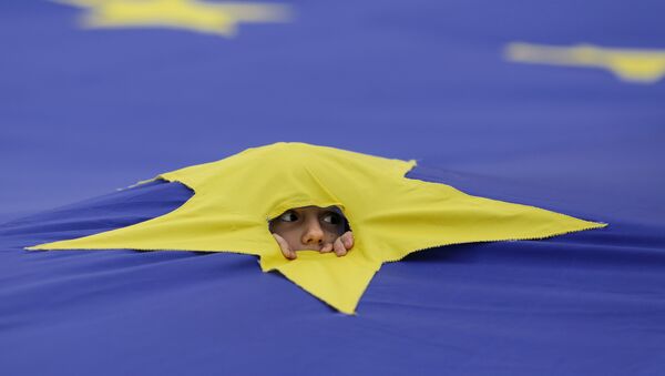 Ребенок смотрит через разрез, сделанный на одной из звезд, которые составляют флаг Европейского Союза, во время митинга поддержки, организованного в честь 60-летия Европейского Союза в Риме, в центре Бухареста, Румыния - Sputnik Afrique