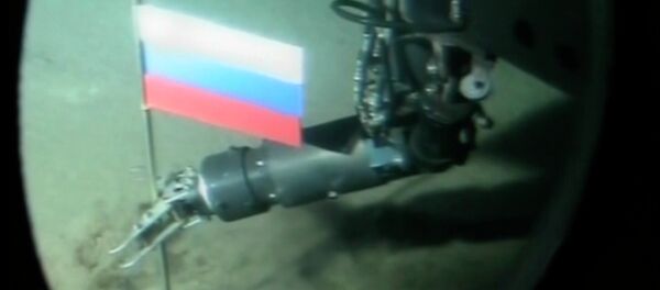 Un opérateur de mini-sous-marin russe plante une capsule de titane avec le drapeau russe pendant une plongée record dans l'océan Arctique sous la glace au pôle Nord - Sputnik Afrique