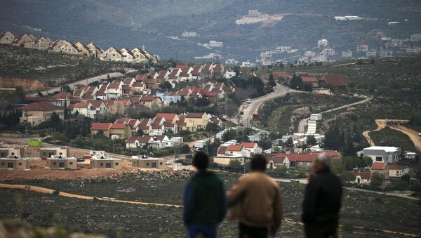 People stand in front of the Jewish settlement of Shvut Rachel during a tour organised by the Palestinian authorities for ambassadors based in Tel Aviv and consuls based in Jerusalem to show the development of Israeli settlements in the occupied West Bank, on March 16, 2017, near the Palestinian village of Jalud. - Sputnik Afrique