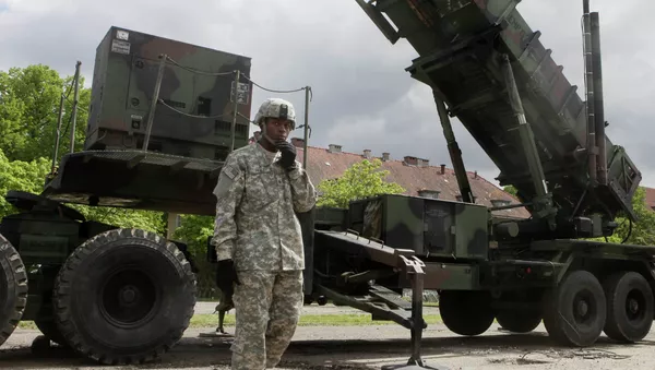 Un soldat américain se trouve à côté d'une batterie de missile sol-air Patriot à une base militaire de Morag, en Pologne - Sputnik Afrique