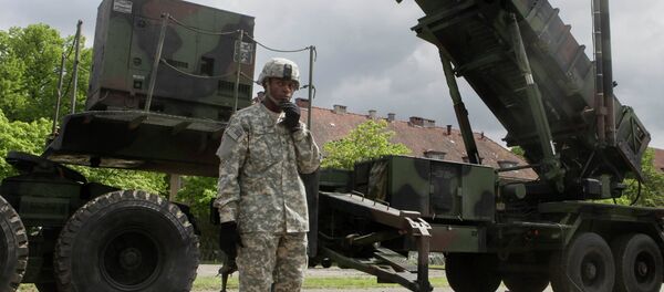 Un soldat américain se trouve à côté d'une batterie de missile sol-air Patriot à une base militaire de Morag, en Pologne - Sputnik Afrique