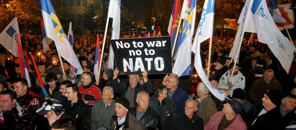 An opposition supporter holds a banner that reads No to war - no to NATO during protest in downtown Podgorica, Montenegro, Saturday, Dec. 12, 2015 - Sputnik Afrique