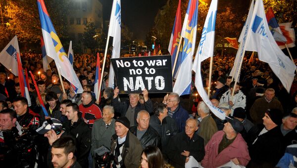 An opposition supporter holds a banner that reads No to war - no to NATO during protest in downtown Podgorica, Montenegro, Saturday, Dec. 12, 2015 - Sputnik Afrique
