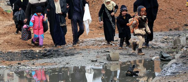 Displaced Iraqi people who fled their homes because of the clashes carry their belongings to go to safe places as Iraqi forces battle with Islamic State militants in Mosul, Iraq, March 13, 2017. - Sputnik Afrique