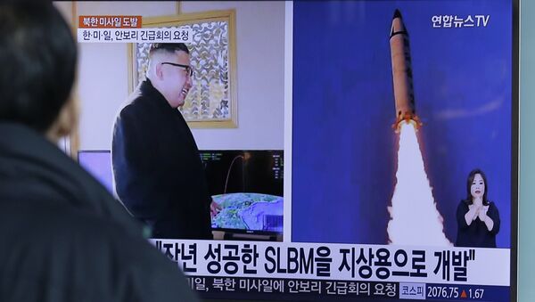 A man watches a TV news program showing photos published in North Korea's Rodong Sinmun newspaper of North Korea's Pukguksong-2 missile launch and North Korean leader Kim Jong Un at Seoul Railway Station in Seoul, South Korea, Monday, Feb. 13, 2017 - Sputnik Afrique