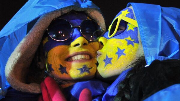 Young protesters with faces painted in colors of Ukrainian and EU flags kiss each other early on December 4, 2013 at a tent camp on Independence Square in Kiev. - Sputnik Afrique